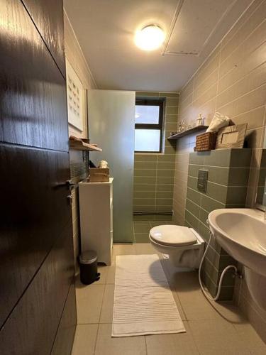 a bathroom with a toilet and a sink at Diplomatic apartment area in Ash Shumaysānī
