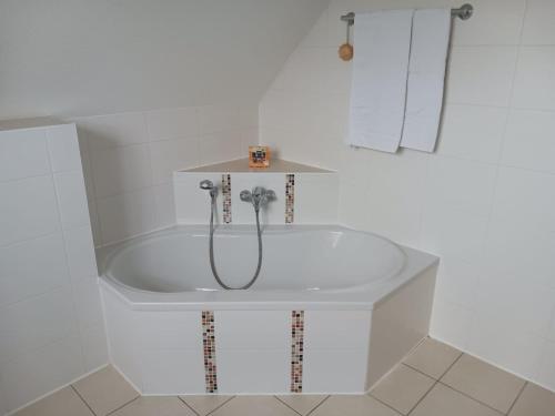 a white bath tub with a shower in a bathroom at Landidylle mit Garten, Whirlpool und Klima in Reken