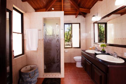 uma casa de banho com um chuveiro, 2 lavatórios e um WC. em Perfect Ocean Hideaway!!! em Parrita