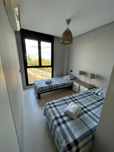 a bedroom with two beds and a large window at Casa Pinto in Villacosta
