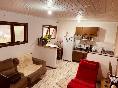 een woonkamer met een bank en een keuken bij Apartamento em ótima localização in Canela