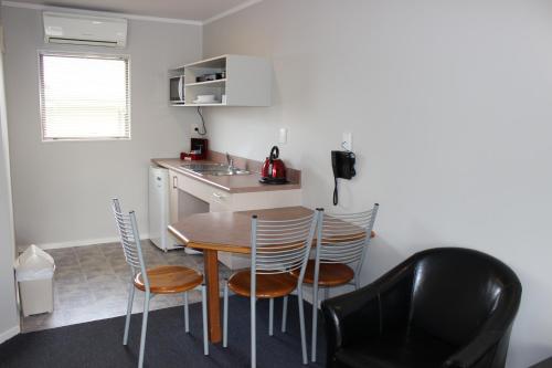 a kitchen and dining room with a table and chairs at Quality Inn Acapulco Taupo in Taupo