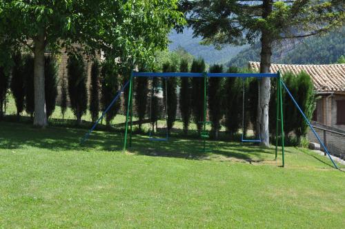a swing set in a park with trees and grass at Hotel Latre in Broto