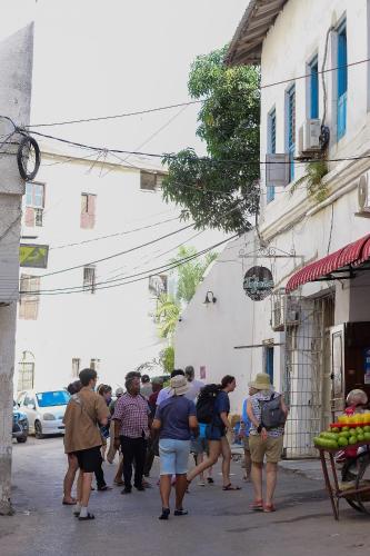 a group of people walking down a street at La Neisha Hotel Zanzibar in Stone Town