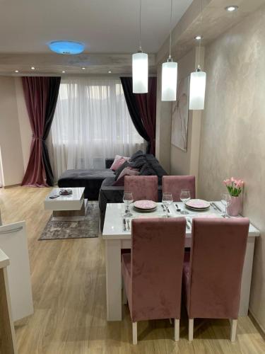 a living room with a table and a couch at Apartman sa ljuljaskom in Zlatibor