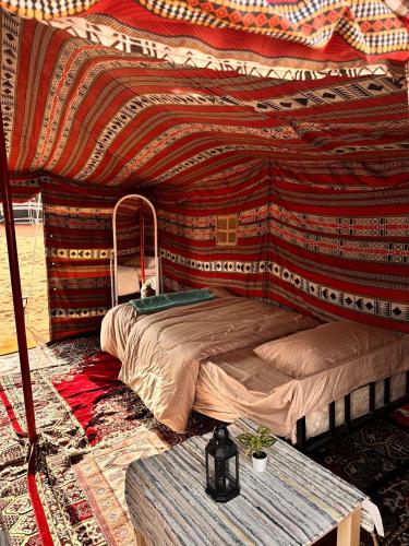 a bedroom with a bed and a table at Authentic Desert Camp 