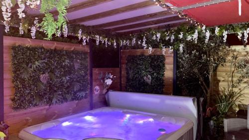 une baignoire jacuzzi dans une pièce ornée de plantes dans l'établissement Un petit coin de Paradis, à Toulouse