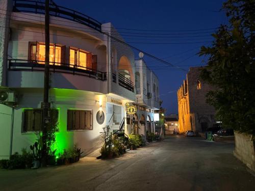 un edificio con luz verde en su lateral en Royal Goddess Guest House, Walled City en Famagusta