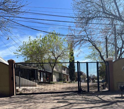 a gate in front of a building with trees at Complejo Lamadrid - semiprivado in Ciudad Lujan de Cuyo