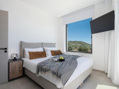 a bedroom with a large bed with a large window at Sunny Vacay Villa in Stérnai
