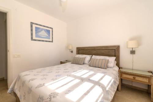 1 dormitorio con 1 cama grande con sábanas blancas en Apartamento junto a la playa en San Bartolomé
