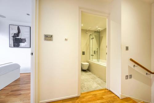 a bathroom with a shower and a toilet in a room at Shoreditch 3-Storey Maisonette - by Living Elite Apartments in Shoreditch