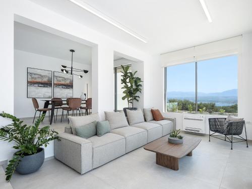 a white living room with a couch and a table at Sunny Vacay Villa in Stérnai