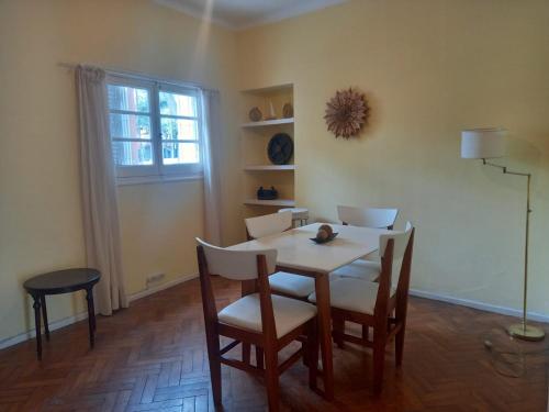 a dining room with a table and chairs and a window at Casa Porto in Mendoza