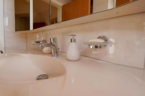 a white sink in a bathroom with a mirror at Tolle Wohnung mit Panoramablick in Weinheim