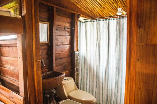 La salle de bains est pourvue de toilettes et d'un lavabo dans une cabine. dans l'établissement Pacuare Mountain Lodge, à Tres Equis