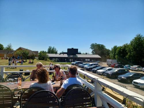 a group of people sitting around a table in a parking lot at Solstickan Hotell & Vandrarhem in Mellbystrand