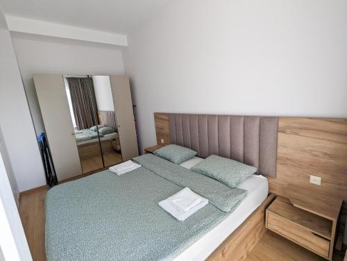 - une chambre avec un lit doté de draps verts et d'un miroir dans l'établissement Brand new apartment in Kutaisi, à Koutaïssi
