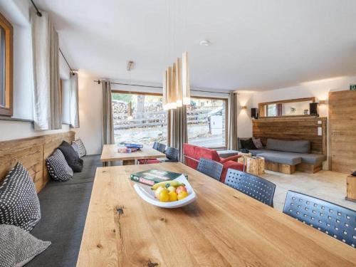 a living room with a wooden table with a bowl of fruit at Burglodge Fischerkeusche in Mauterndorf