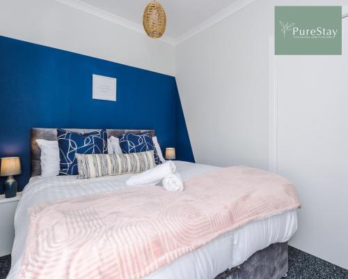 a bedroom with a bed with a blue wall at Fantastic Four Bedroom Family Home By PureStay Short Lets & Serviced Accommodation Merseyside Liverpool in Liverpool