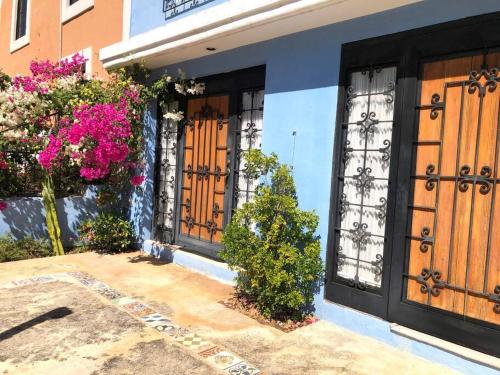 a house with black and wooden doors and flowers at Casa Eugenia 35 / Centro Histórico in Campeche