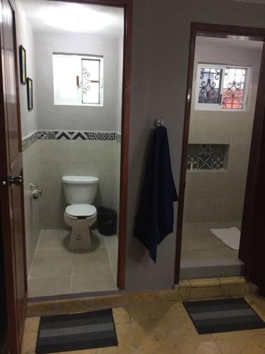 a bathroom with a toilet and a door with a towel at Casa Eugenia 35 / Centro Histórico in Campeche