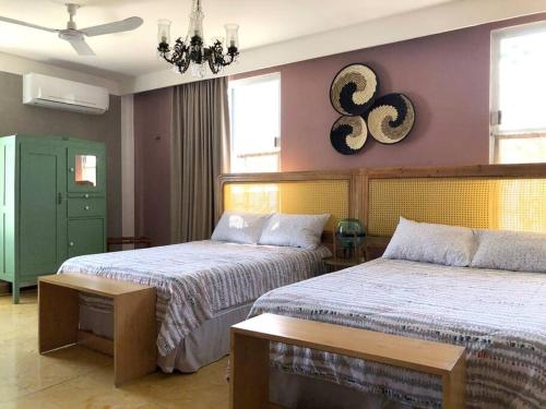 a bedroom with two beds and a chandelier at Casa Eugenia 35 / Centro Histórico in Campeche