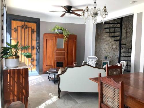 a living room with a table and a ceiling fan at Casa Eugenia 35 / Centro Histórico in Campeche