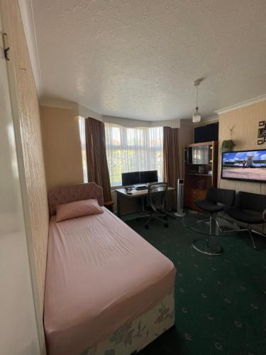 a hotel room with a bed and a desk at Double room in Canvey