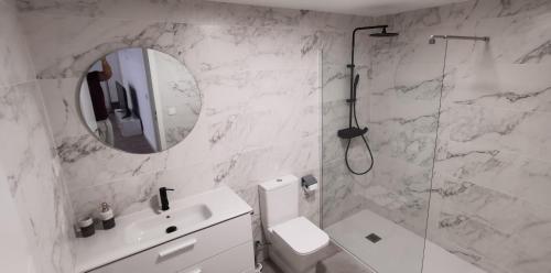 W łazience znajduje się toaleta, umywalka i lustro. w obiekcie Piso de lujo 2 habitaciones w mieście Las Rozas de Madrid