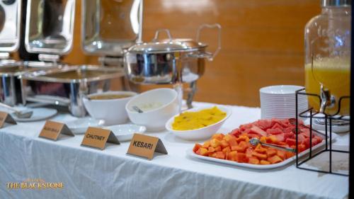 uma mesa com um buffet de frutas e legumes em Hotel The Black Stone em Bangalore