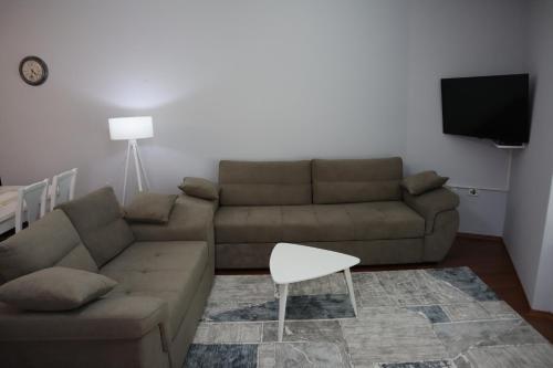 a living room with a couch and a tv at Prima Apartments in Pogradec