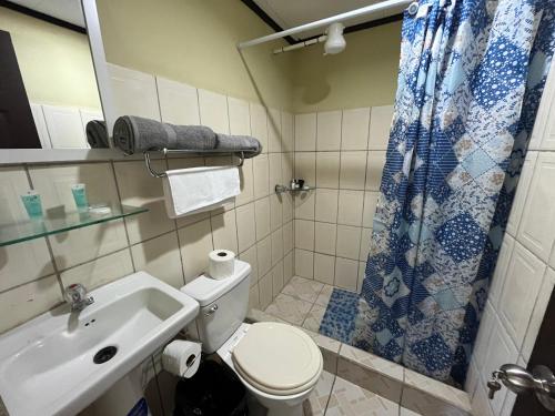 y baño con aseo, lavabo y ducha. en Hotel Azul Coral, en Cahuita