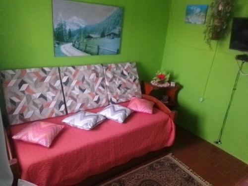 - une chambre avec un lit rose dans une pièce verte dans l'établissement La Coronilla ,Casa de Campo, à La Coronilla