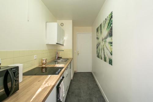 une cuisine avec un évier et un plan de travail dans l'établissement Appartement Glaciere, à Paris