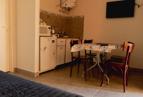 cocina con mesa, sillas y nevera en LOS GURISES en Villa Elisa