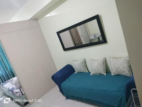 - une chambre avec un lit bleu et un miroir dans l'établissement Sea Residences Tower E&B - AURUM, à Manille