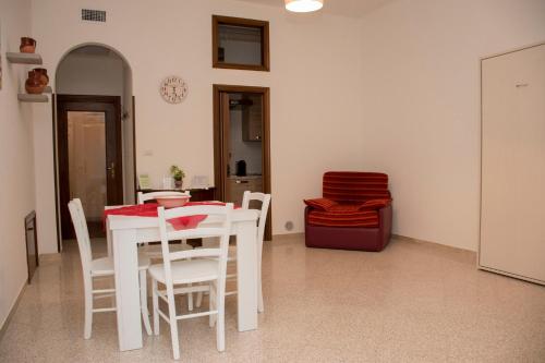 een witte eetkamer met een tafel en stoelen bij Locorotondo Home Holidays in Locorotondo