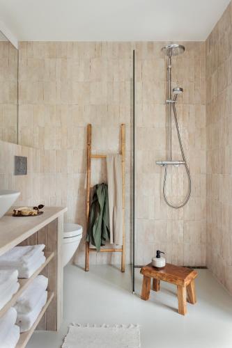 a bathroom with a shower and a toilet and a table at Hus 42 in Fårup