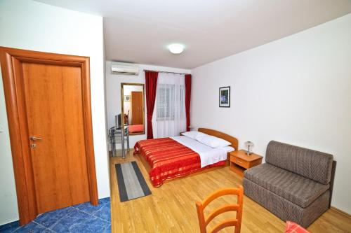 a bedroom with a bed and a couch and a chair at Apartments Bozikovic in Podstrana