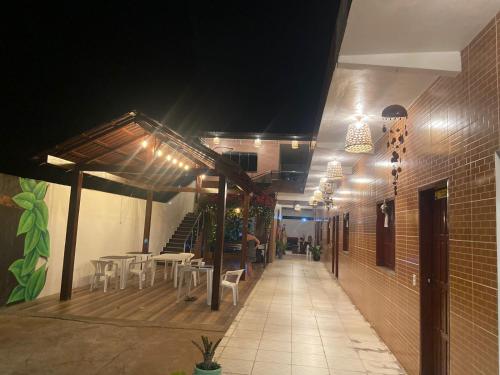 ein Restaurant mit Tischen und Stühlen auf einer Terrasse in der Nacht in der Unterkunft POUSADA ECOALTER in Santarém