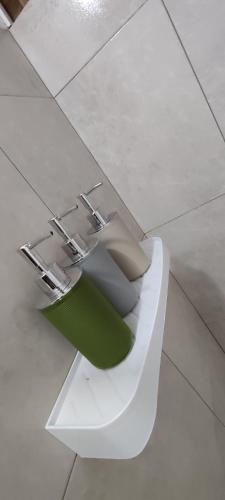 a toilet with a green paper sitting on top of it at Garden House Puerto López in Puerto López