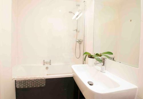 een witte badkamer met een wastafel en een douche bij Oxford CityCenterTrainStation two bedroomApartment in Oxford