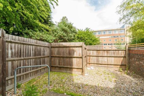 a wooden fence with a gate in a yard at Oxford CityCenterTrainStation two bedroomApartment in Oxford