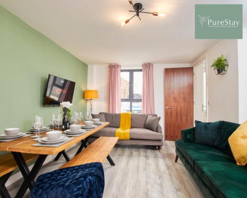 ein Wohnzimmer mit einem grünen Sofa und einem Tisch in der Unterkunft Perfect for Business Stays in Manchester - 5 Bedroom House By PureStay Short Lets & Serviced Accommodation in Manchester