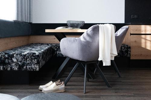a desk with a chair and a table with at Apart-Pension Bergland in Ladis