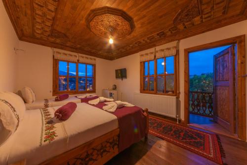 1 dormitorio con 2 camas y ventana grande en Manzara Konak Otel, en Safranbolu
