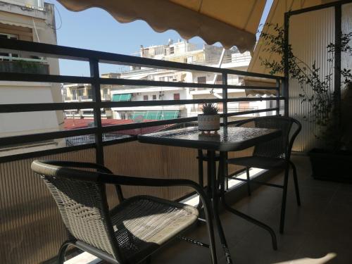 a table and chairs on a balcony with a window at Central Home in Kalamata