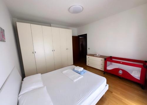 Un dormitorio con una cama blanca y una cómoda roja en Appartamento Mesi, en Conegliano