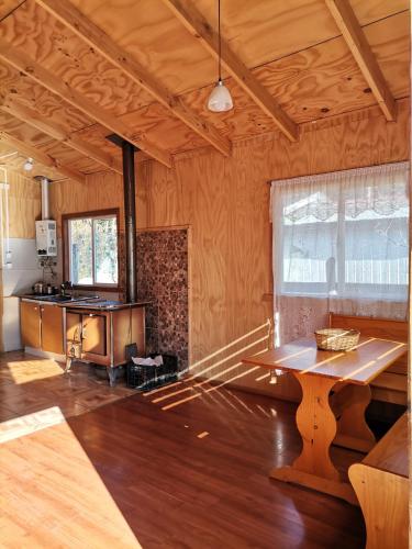 una sala de estar con una mesa en el centro de una habitación en Sol de la Patagonia Bahía Murta, en Bahía Murta